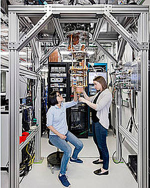Los científicos Hanhee Paik (izquierda) y Sarah Sheldon (a la derecha) examinan el hardware dentro de una nevera de dilución abierta en el IBM Q Lab.